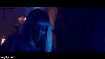 a man and a woman are dancing in a dark room in a blue light .
