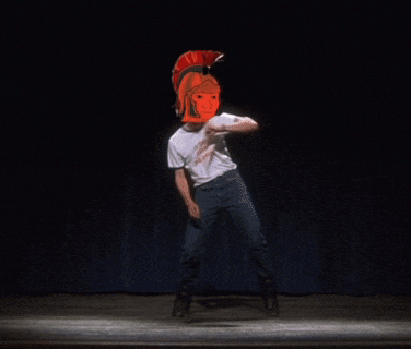 a man with a spartan helmet on his head dancing on a stage
