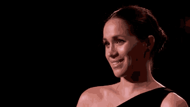 a close up of a woman in a black dress on a stage .