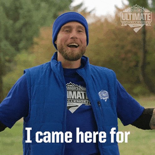 a man wearing a blue vest that says i came here for on it