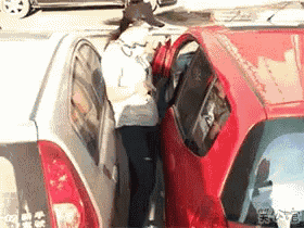 a woman is standing between two cars in a parking lot .