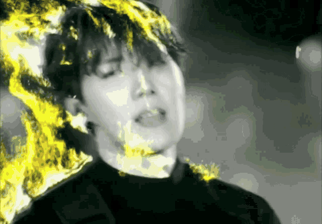 a close up of a person 's face with yellow flames coming out of it
