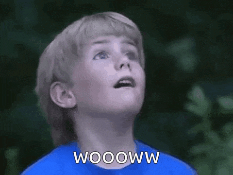 a young boy in a blue shirt is looking up and saying wooww