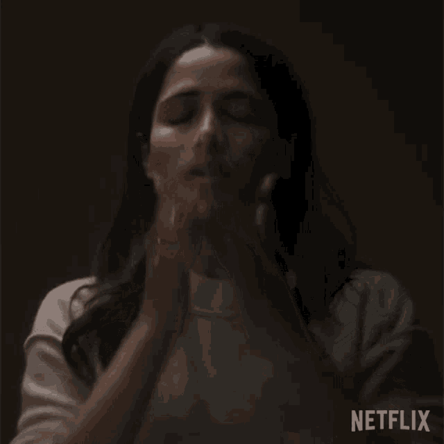 a woman covering her face with her hands with the netflix logo in the corner