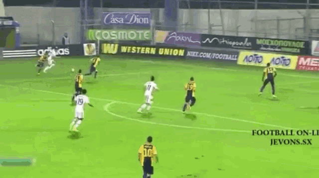 a group of soccer players are playing on a field with advertisements for kanabet