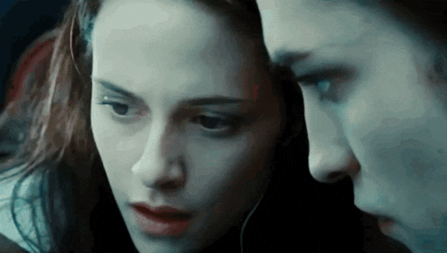a close up of a woman 's face with a man behind her