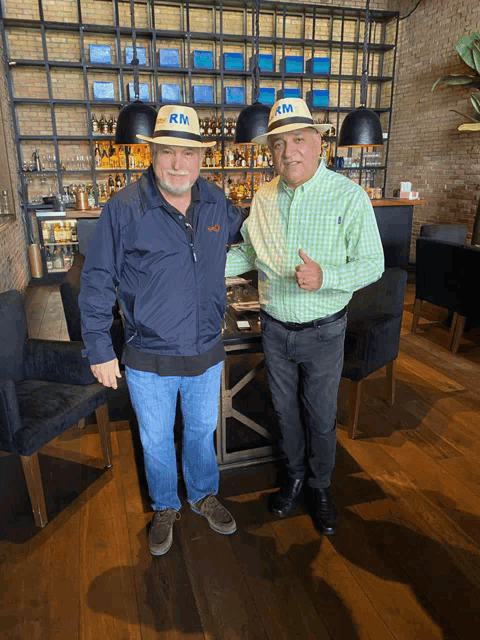 two men wearing hats that say rm on them