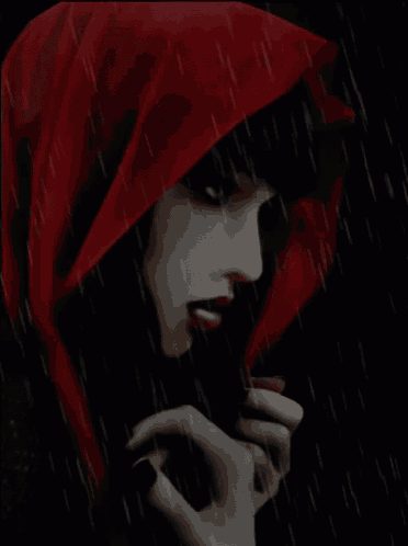 a woman wearing a red hood stands in the rain