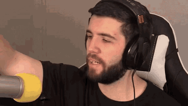 a man with a beard is wearing headphones and a yellow microphone