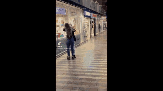 a woman is hugging another woman in front of a store that says tiger