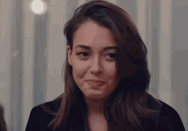 a woman with long hair is making a funny face while looking at the camera .