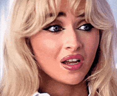 a woman with blonde hair and blue eyes is making a funny face