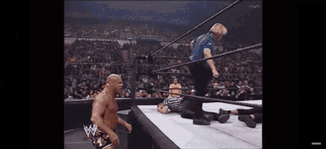 a wrestler in a wrestling ring with a referee in the background