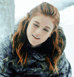 a woman with red hair wearing a fur coat is smiling