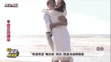 a man is carrying a woman in his arms on a beach .