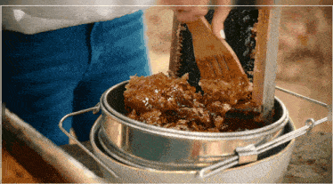 a person is scooping honey out of a honeycomb