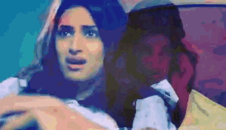 a man and a woman are sitting in a car with the woman making a surprised face