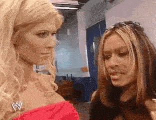 two women are standing next to each other and looking at each other in a room .