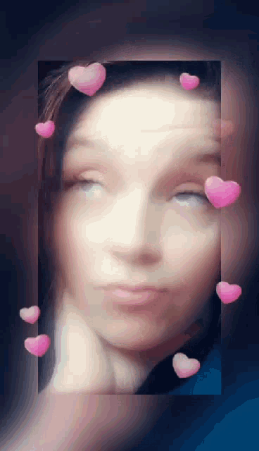 a woman 's face is framed by pink hearts