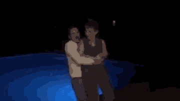 a person is swimming in a pool with blue lights on it