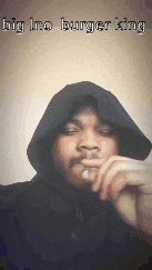 a man in a hooded jacket smoking a cigarette with the words big ino burger king written on the bottom