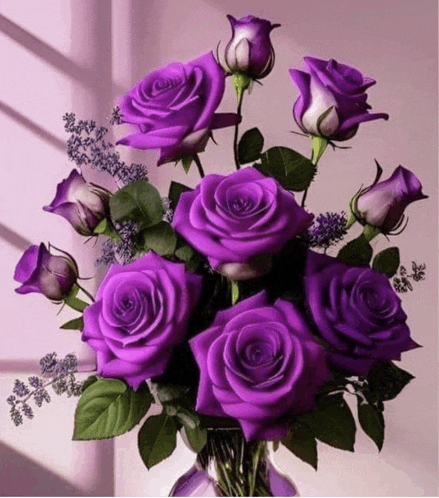 a vase filled with purple roses and lavender