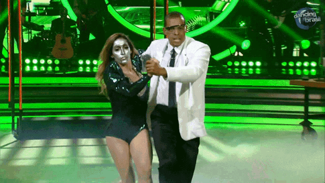 a man and a woman are dancing on a stage with dancing brasil written on the bottom