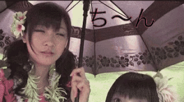 a woman holding an umbrella with a flower in her hair