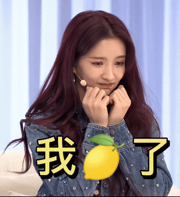 a woman in a denim jacket holds her hands to her face with a lemon in front of her with chinese writing on it
