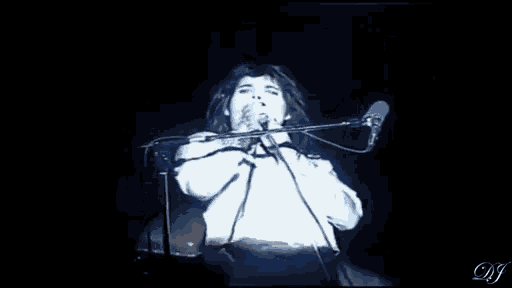 a man is playing a violin and singing into a microphone .