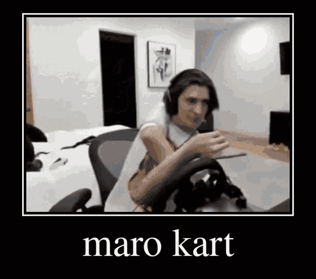 a man wearing headphones is sitting in a chair holding a steering wheel .