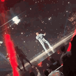 a man stands on a stage with a microphone in his hand