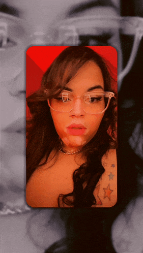 a woman wearing glasses and a choker has a tattoo of stars on her chest
