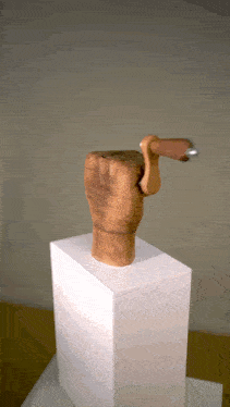 a wooden statue of a hand holding a hammer