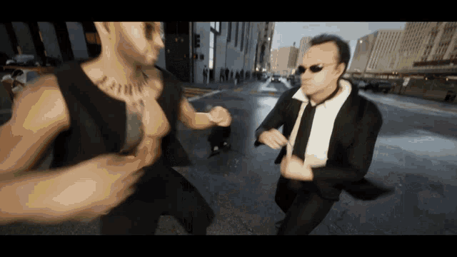 a man with a tattoo on his chest is standing next to a man in a suit and tie