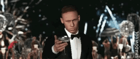 a man in a tuxedo is holding a glass of champagne in his hand
