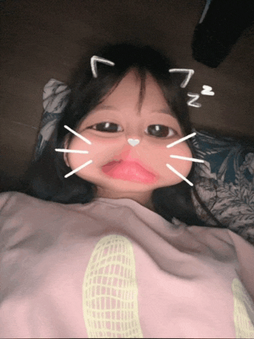 a little girl is making a cat face with the letter n on her head