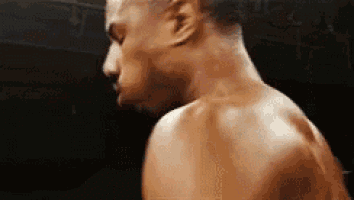 a man is standing in a boxing ring with his back to the camera .