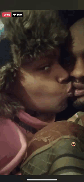 a man and woman kissing in a live video