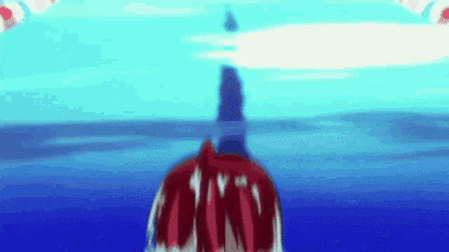 a person in a red cape is standing in the ocean looking up at the sky .
