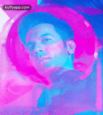 a close up of a man 's face in a pink and blue light .