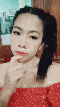 a woman in a red off the shoulder top with white polka dots on it