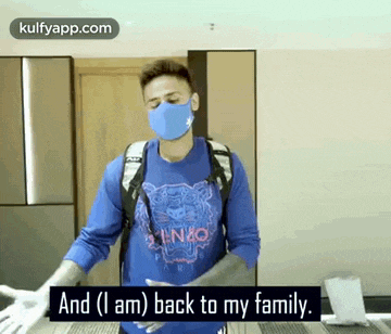 a man wearing a mask and a blue shirt is talking about his family .