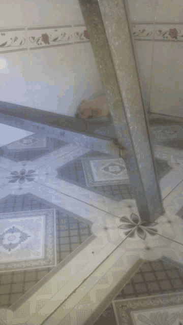 a gray and white tile floor with a floral design on it