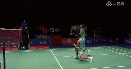 two players on a badminton court one of whom has the number 33 on his jersey