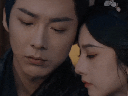 a man and a woman are looking at each other with their eyes closed