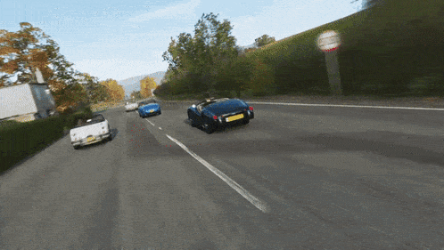 a few cars are driving down a road and one of them has a license plate that says ' a '