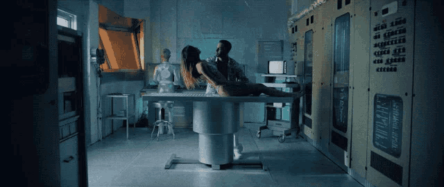 a woman is laying on a table in a dark room with a sign that says ' electrical ' on it