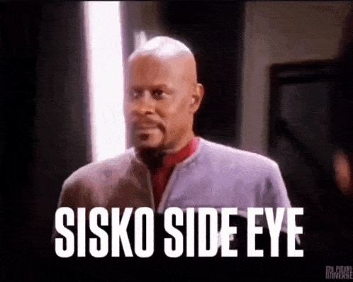 a man is standing in a room with the words sisko side eye written on a black background .
