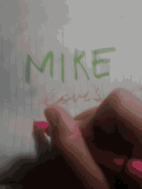 a person writes the name mike on a white board